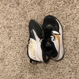 Nike black white and gold shoes
